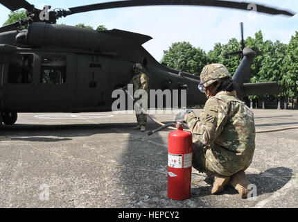 Zwei Soldaten, ein Boden-Crew-Team gehören zum 4-3 Assault Helicopter Bataillon, denen direkt 2. Geschwader, 2. Kavallerie-Regiment, Kraftstoff ein UH-60 Black Hawk Hubschrauber während einer Kraftstoff-Punkt unterstützt zugeordnet stoppen in seiner Reise nach Sinaia, Rumänien, während der Teilnahme an der Einheit Kavallerie März von Mihail Kogalniceanu Air Base in Cincu Training Center, 14. Mai 2015. Dieses Ereignis konzentriert sich nicht nur auf den Transport von Soldaten und ihre Ausrüstung zu einer neuen rumänischen Ausbildungsstätte, sondern es wird auch der Einheit eine Chance zur Interaktion mit der örtlichen Bevölkerung und über die Beziehungen zu verbessern, ihre Stockfoto