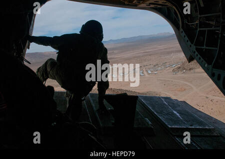 Ein UH-64 Chinook-Crew-Mitglied mit der 1. Kavallerie-Brigade der Luft, hält 1. Kavallerie-Division an einem Griff wie die Luft zum Handwerk mock stadtauswärts in die National Training Center, 1.Mai an Fort Irwin, Kalifornien fliegt Das Flugzeug wurde verwendet, um die Soldaten mit der 3. Pionierbataillon abholen, 3rd Armored Brigade Combat Team, wie sie aus der Stadt evakuiert. (US Armee-Foto von Sgt. Brandon Banzhaf, 3rd Armored Brigade Combat Team, 1. Kavallerie-Division) 3. ABCT NTC Drehung 150501-A-FJ427-495 Stockfoto