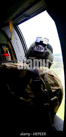 Ein UH-60 Black Hawk Crewchief von 4. Bataillon, 3. Aviation Regiment, 3. Combat Aviation Brigade, 3. Infanterie-Division aus Hunter Army Airfield, Georgia, statt Monitore Landung während eines Trainings mass Casualty in Camp Adazi, Lettland, Juni 8. Black Hawk-Hubschrauber zur Verfügung gestellt medizinische Evakuierung Fähigkeiten für das medizinische Personal der Combat Support Battalion, lettische Land Forces Brigade während der Übung. Die Übung zur Verfügung gestellt einer Demonstration der gemeinsamen medizinischen Fähigkeiten der Streitkräfte aus 13 verschiedenen Nationen und Land- und Luftweg medizinische Anlagen enthalten. Die Übung fand in Verbindung Stockfoto