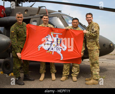 Von links nach rechts sind die litauischen Land Forces Master Sgt. Gintautas Mauricas, Generalmajor Patrick Wilde, Staff Sgt Carlos Cruz und Chief Warrant Officer 2 Justin Warren. Die drei amerikanische Soldaten sind Chock 4, ein UH - 60 M Blackhawk wird geflogen von Soldaten zugewiesen B Company, 43. Angriff Hubschrauber-Bataillon, 3. Kavallerie-Regiment, 3. US-Infanteriedivision während des Trainings Saber Strike 2015, Jonava, Litauen, 16. Juni 2015 zugeordnet. Säbel-Strike ist eine langjährige US-Army in Europa führte kooperative Übung. Das diesjährige Übung Ziele erleichtern die Zusammenarbeit zwischen den USA, Estland, Lat Stockfoto