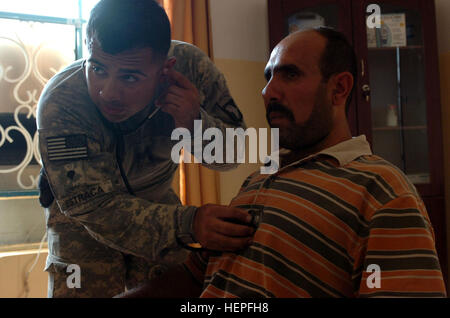 SPC. Leonard Estraca, ein Eingeborener von Mathis, Texas, überprüft Söhne des Irak, Abna'a al-Irak, Mitglied oder der Herzschlag während ein medizinisches Screening in Radwaniyah am 21. August 2008. Estraca serviert mit Batterie B, 1. Bataillon, 320th Field Artillery Regiment, 2nd Brigade Combat Team, 101st Airborne Division (Air Assault), Multi-National Division - Bagdad. Top Gun Truppen temporäre Bekämpfung Außenposten im Radwaniyah eingerichtet, um feindliche Bewegung 111874 Einhalt zu Gebieten Stockfoto