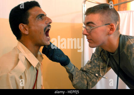 SPC. Benjamin Ulery, ein Eingeborener von Jay, Maine, überprüft Söhne des Irak, Abna'a al-Irak, Mitglied oder die Mandeln während ein medizinisches Screening in Radwaniyah am 21. August 2008. Ulery serviert mit Batterie B, 1. Bataillon, 320th Field Artillery Regiment, 2nd Brigade Combat Team, 101st Airborne Division (Air Assault), Multi-National Division - Bagdad. Top Gun Truppen temporäre Bekämpfung Außenposten im Radwaniyah eingerichtet, um feindliche Bewegung 111870 Einhalt zu Gebieten Stockfoto