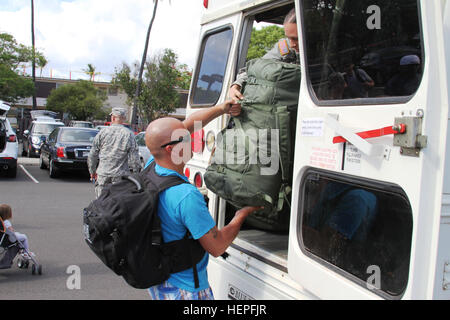 Eine Schiffskameraden von 163. Transport Abteilung (logistische Unterstützung Schiff), 524th Bekämpfung Sustainment Support Battalion, 45. Sustainment Brigade lädt seine Koffer in einen Bus nach Honolulu International Airport, 20 Juni gebunden. Die über 30 Mitglieder der Abteilung werden in den Persischen Golf betreiben die US Army Central Command Mission zu unterstützen. Die Ablösung Abschied von ihren Familien und Einheit während einer bittersüßen Zeremonie auf gemeinsamer Basis Pearl Harbor-Hickam, Hawaii. Pacific Waterborne Krieger bereitstellen nach Kuwait zur Unterstützung von CENTCOM-150620-A-KC411-005 Stockfoto