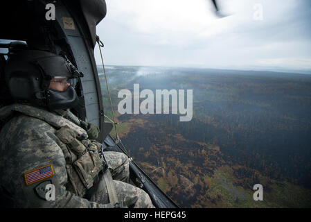 Diesen Sommer wurde voll von Waldbränden in ganz Alaska. Zahlreiche Feuerwehr-Teams haben aus den unteren Vereinigten Staaten im Kampf helfen aufgerufen wurde. Eines der Teams, die im Kampf beigetreten ist ein lokales Team, der Alaska Army National Guard. Mit zwei UH-60 Black Hawk-Hubschrauber und Bambi-Eimer, haben die Alaska Army National Guard Teams Brandbekämpfung Missionen in Abstimmung mit dem Bureau of Land Management, Feuerwehren, Sitz in Fort Wainwright, Alaska durchführen. Am Freitag, dem 26. Juni flog das Team ihre Flugzeuge bis Tok, Alaska, zur Unterstützung bei der Bekämpfung von ein paar großen f Stockfoto