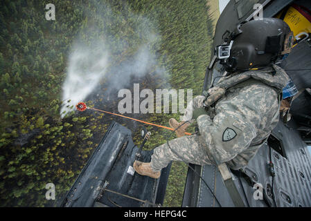 Diesen Sommer wurde voll von Waldbränden in ganz Alaska. Zahlreiche Feuerwehr-Teams haben aus den unteren Vereinigten Staaten im Kampf helfen aufgerufen wurde. Eines der Teams, die im Kampf beigetreten ist ein lokales Team, der Alaska Army National Guard. Mit zwei UH-60 Black Hawk-Hubschrauber und Bambi-Eimer, haben die Alaska Army National Guard Teams Brandbekämpfung Missionen in Abstimmung mit dem Bureau of Land Management, Feuerwehren, Sitz in Fort Wainwright, Alaska durchführen. Am Freitag, dem 26. Juni flog das Team ihre Flugzeuge bis Tok, Alaska, zur Unterstützung bei der Bekämpfung von ein paar großen f Stockfoto
