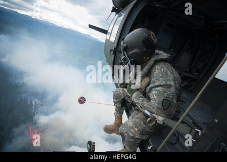 Diesen Sommer wurde voll von Waldbränden in ganz Alaska. Zahlreiche Feuerwehr-Teams haben aus den unteren Vereinigten Staaten im Kampf helfen aufgerufen wurde. Eines der Teams, die im Kampf beigetreten ist ein lokales Team, der Alaska Army National Guard. Mit zwei UH-60 Black Hawk-Hubschrauber und Bambi-Eimer, haben die Alaska Army National Guard Teams Brandbekämpfung Missionen in Abstimmung mit dem Bureau of Land Management, Feuerwehren, Sitz in Fort Wainwright, Alaska durchführen. Am Freitag, dem 26. Juni flog das Team ihre Flugzeuge bis Tok, Alaska, zur Unterstützung bei der Bekämpfung von ein paar großen f Stockfoto