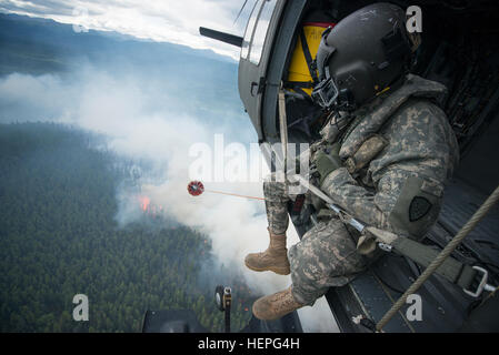 Diesen Sommer wurde voll von Waldbränden in ganz Alaska. Zahlreiche Feuerwehr-Teams haben aus den unteren Vereinigten Staaten im Kampf helfen aufgerufen wurde. Eines der Teams, die im Kampf beigetreten ist ein lokales Team, der Alaska Army National Guard. Mit 2 UH-60 Black Hawk-Hubschrauber und Bambi-Eimer der Alaska Army National Guard haben Mannschaften Brandbekämpfung Missionen in Abstimmung mit dem Bureau of Land Management, Feuerwehren, Sitz in Fort Wainwright, Alaska durchführen. Am Freitag, den 26. Juni flog das Team ihre Flugzeuge bis Tok, Alaska, zur Unterstützung im Kampf gegen ein paar große Brände Stockfoto