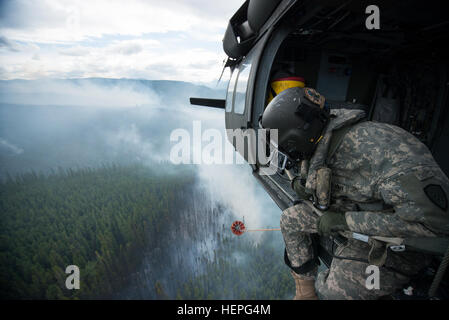 Diesen Sommer wurde voll von Waldbränden in ganz Alaska. Zahlreiche Feuerwehr-Teams haben aus den unteren Vereinigten Staaten im Kampf helfen aufgerufen wurde. Eines der Teams, die im Kampf beigetreten ist ein lokales Team, der Alaska Army National Guard. Mit zwei UH-60 Black Hawk-Hubschrauber und Bambi-Eimer, haben die Alaska Army National Guard Teams Brandbekämpfung Missionen in Abstimmung mit dem Bureau of Land Management, Feuerwehren, Sitz in Fort Wainwright, Alaska durchführen. Am Freitag, dem 26. Juni flog das Team ihre Flugzeuge bis Tok, Alaska, zur Unterstützung bei der Bekämpfung von ein paar großen f Stockfoto