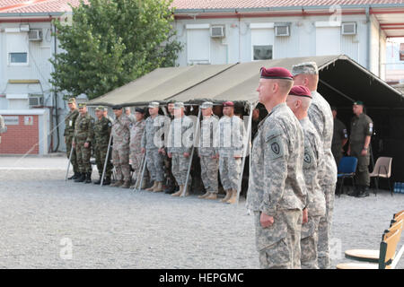 Lt. Col Mark D. Federovich (vorne), scheidenden Kommandeur von der multinationalen Battle Group-Ost nach vorn Gefechtsstand, neben der MNBG-E Kommandeur, Oberst Clinton J. Baker und eingehende FCP Kommandeur, Oberstleutnant William J. Gray, Stand mit multinationalen Gäste und aufstrebenden Besucher während des Übergangs der Behörde Zeremonie 4. Juli 2015, im Camp Marechal de Lattre de Tassigny, Kosovo. Federovich Befehle 1. Staffel (Airborne), 40. Kavallerie-Regiment, 4th Infantry Brigade Combat Team (Airborne), 25. Infanterie-Division, aus gemeinsamen Basis Elmendorf-Richardson, Alaska. Grau-1. kombinierte Befehle Stockfoto