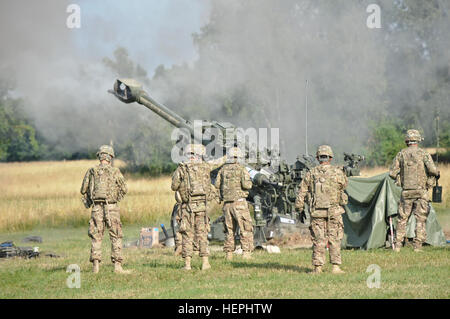 Troopers zugewiesen an Alpha Batterie Feldartillerie Geschwader, 2. Kavallerie-Regiment, Feuer ein M777A2 Haubitze Waffensystem während ihrer Einheit Artillerie Demonstration, wo sie zum ersten Mal in der Geschichte des Regiments in Grafenwöhr Training Area befindet sich in der Nähe von Rose Barracks, Deutschland, 24. Juli 2015 eine XM1156 Präzision Guidance Kit Sicherung ausgelöst. Die Demonstration erlaubt das Regiment zur Teilnahme an Neumaschinen training wo der PGK-Sicherung (die globale Positionierung Systemfunktionen, die darauf, zur Erhöhung der Genauigkeit der hochexplosive und Rocket-Assisted Projektil Artillerie runden abzielen) wi Stockfoto