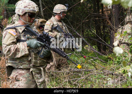 SPC. Camilo Araujo (links) und Pvt. Zachary Pogue (rechts), beide Fallschirmjäger mit der US-Armee Unternehmen C, 2. Bataillon, 503. Infanterieregiment 173rd Airborne Brigade, geben Sie eine Holz Zeile, sobald er sich mock Ziele 6. August 2015, während der Vorbereitung für Leben-Heißausbildung in Yavoriv, Ukraine. Fallschirmjäger aus der 173rd Airborne Brigade sind in der Ukraine für die zweite von mehreren geplanten Umdrehungen zu trainieren, dass der Ukraine neu Nationalgarde im Rahmen des furchtlosen Wächter, gebildet, die zum letzten bis November geplant ist. (US Armee-Foto von Sgt. Alexander Skripnichuk, 13. Public Affairs-Detachmen Stockfoto