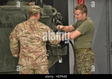 Sgt. Dillon Munn (links), ein Panzerschützen zugeordnet Waffen Truppe, 4. Staffel, 2. Kavallerie-Regiment, hilft ein Mitglied der Streitkräfte der Slowakischen Republik Kraftstoff in seiner Einheit Fahrzeug zu ersetzen, da sie weiterhin für Wartungen, Prüfungen und Dienstleistungen nach der Ankunft in der Slowakischen Republik während Dragoon Crossing, eine taktische Straße marschieren ausgehend in Rose Barracks, Deutschland und dann in der Tschechischen Republik und der Slowakischen Republik endet in Ungarn am 15. Sept. , 2015. Der Zweck der Übung ist es, NATO-Verbündeten der USA Absicht während Operation Atlantic lösen und beruhigen Stockfoto