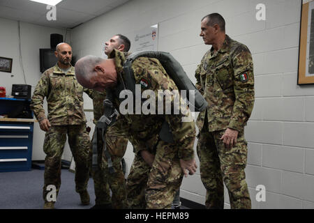 Italienische Major General Enrico Pollini der Associazione Nazionale Paracadutusti D'Italia stellt auf der US-Armee Notfall Bail-Out Anzug während andere italienische Soldaten warten zu unterstützen in Fort Bragg, N.C., 11. November 2015. USA und Partner Nation Soldaten trainieren für luftgestützte Operationen zur Unterstützung der Operation Spielzeug fallen. (US Armee-Foto von Pfc. Darion Gibson/freigegeben) Betrieb Spielzeug Tropfen 151130-A-JW364-014 Stockfoto