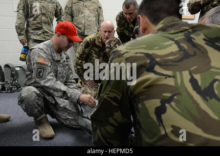 US Army Staff Sgt Lee Stephenson von Airborne spezielle Test Betriebsdirektion weist Partnerland springen Masters zur Verwendung der US-Armee Notfall Bail-Out-Anzug in Fort Bragg, N.C., 11. November 2015. Betrieb Spielzeug Drop ist der weltweit größte zerstreute Betrieb in Kombination mit sieben teilnehmenden Partner-Nation-Fallschirmjäger und Soldaten die Möglichkeit zu helfen, Kinder in Not überall Spielzeug für den Urlaub erhalten. (US Armee-Foto von Pfc. Darion Gibson/freigegeben) Betrieb Spielzeug Tropfen 151130-A-JW364-011 Stockfoto