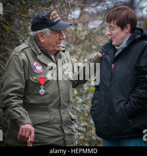 Genau an der Stelle von seinem ehemaligen Fuchsloch erzählt Vincent Speranza, ein WWII Schlacht der Ausbuchtung Veteran, einige der traurigen sowie lustige Geschichten aus seiner Zeit bei der 101. US-Luftlandedivision während der Belagerung von Bastogne, Belgien, mit seiner Tochter Ella Broche, 11. Dezember 2015. Speranza ist der Autor von "Nüssen! Ein 101st Airborne Division MG-Schütze in Bastogne." (US Armee-Foto von Staff Sgt. Bernardo Fuller/freigegeben) Bastogne und das Gesicht der Schlacht 151211-A-AJ780-007 Stockfoto