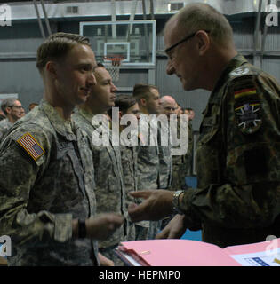 US Army Captain Justin Elliott, ein West Virginia Nationalgarde Offizier dienen im Kosovo mit multinationalen Battle Group-Ost, akzeptiert die deutschen Streitkräfte Proficiency Abzeichen aus deutschen Oberst Hans-Jürgen Freiherr von Keyserlingk, Commander für das deutsche Kontingent im Kosovo, 29. Dezember 2015, am Camp Bondsteel, Kosovo. Um das Abzeichen zu verdienen, abgeschlossen Soldaten einen 100-Meter-schwimmen während des Tragens ihrer vollen Dienst Uniform, einen Ruck-Marsch und andere Veranstaltungen testen ihre Treffsicherheit und körperliche Fitness. (Foto: US-Armee Sgt. Erick Yates, multinationalen Battle Group-Ost) US-Soldaten verdienen deutsche p Stockfoto