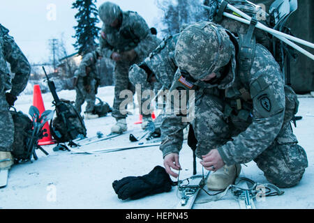 Fallschirmjäger der 4th Infantry Brigade Combat Team (Airborne) 25. Infanterie-Division setzen auf Langlaufskiern in Fort Wainwright, Alaska, während der US-Armee Alaska arktischen Winterspiele 27. Januar 2016. Veranstaltungen enthalten, eine schriftliche Prüfung, zwei-Meile Ahkio ziehen, Schneeschuh Ruck März, Behandlung von einem kalt-Wetter-Unfall, arktischen 10-Mann-Zelt und Herd, Bohrer, Skijöring, Biathlon und Skifahren. (Foto: U.S. Army Staff Sgt Daniel Love) Setzen von Skiern 160131-A-NC569-413 Stockfoto