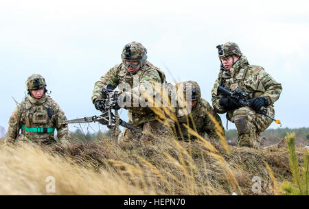 PFC Jose Gil, ein Infanterist mit L-Truppe, 3. Staffel, 2. Kavallerie-Regiment, setzt sich seine M240 Maschinengewehr während eines Team-live-Feuer-Trainings während Staff Sgt Michael Chargualaf, seine Gruppenführer blickt auf. (Foto: U.S. Army Staff Sgt Michael Behlin) 2. Kavallerie-Regiment stellt den USA für litauische Fernsehpublikum 160202-A-RJ696-041 Stockfoto