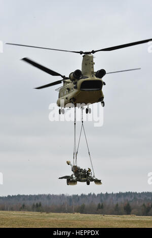 Troopers zugewiesen Archer Batterie, Field Artillery Geschwader, 2. Kavallerie-Regiment, mit Unterstützung von einem 12th Combat Aviation Brigade CH-47 Chinook Hubschrauber Besatzung führen Schlinge Last training mit M777 Haubitzen während der Staffel Artillerie Systeme Kooperationen bei der 7. Armee gemeinsame multinationale Ausbildung des Befehls Grafenwöhr Training Area Germany, 21. März 2016. (US Army Foto von visuellen Informationen Spezialist Gertrud Zach/freigegeben) Feldartillerie, 2CR, führt Schlinge Last training mit M777 160321-A-HE359-270 Stockfoto