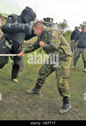 CPL. Fundulea, Militärpolizei mit rumänischen Landstreitkräfte Praktiken Baton einzigen Streik Techniken während eines mock Riot Control Trainings in Cincu Trainingsbereich, Rumänien am 10. Mai 2016.  Demonstration in die "Red-Man-Anzug" ist Spc. Landon Glover, Militärpolizei mit 1165th Military Police Company, Alabama National Guard.   (US Armee-Foto von CPT. Ryan E. Black, 877th Engineer Battalion, Alabama National Guard) 1165th Military Police Company, Alabama Army National Guard Kreuz-Züge mit rumänischen Militärpolizei (Bild 1 von 5) 160509-A-CS119-004 Stockfoto