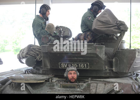 Slowenische Soldaten der 45. Center für verfolgt bekämpfen Fahrzeuge (CGBV) legen die mehrere integrierte Laser Engagement Systeme (Meilen) auf einem Kampfpanzer m bei Swift Antwort 16 Übung auf dem Truppenübungsplatz Hohenfels, ein Teil der Joint Multinational Readiness Center in Hohenfels, Deutschland, 8. Juni 2016. Übung Swift Antwort ist eines der führenden militärischen Krise Antwort Fortbildungsveranstaltungen für multi-nationalen Luftstreitkräfte der Welt. Die Übung soll die Bereitschaft zum Kampf gegen Kern der US Global Response Force – derzeit der 82nd Airborne Divi verbessern Stockfoto