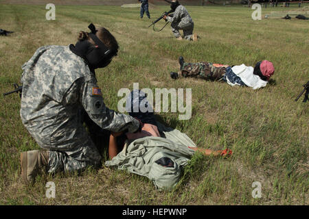 A U.S. Army medic from the 108th Multifunction Medical Battalion treats a simulated casualty during lifesaving training at West Camp Rapid in the Golden Coyote exercise, focusing on warrior tasks and battle drills. Stockfoto