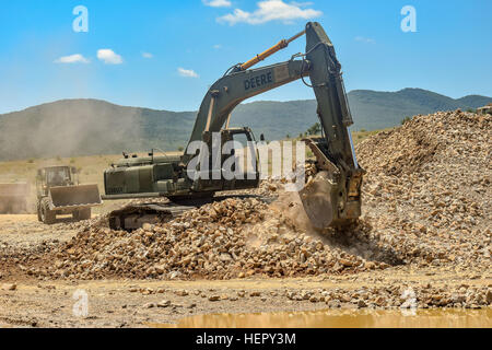 Ein Hydraulikbagger betriebene militärische Ingenieure aus dem 841st Ingenieur-Bataillon, US Army Reserve bewegt sich Felsen in der Nähe einer Straße im Bau am 6. Juli 2016 in Novo Selo Trainingsbereich, Bulgarien während Operation Resolute Schloss 2016.  Soldaten aus dem 841st Pionier-Bataillon verbrachte den Sommer 2016 arbeiten mit Service-Mitglieder aus der Army National Guard in Tennessee und Mississippi Army National Guard ein Tank Trainingsbereich und Munition Wartebereich in Bulgarien zu verbessern.  (Foto: U.S. Army Captain Kimberlee Lewis, 841st Engineer Battalion, US Army Reserve) 194. Engineer Brigade c Stockfoto