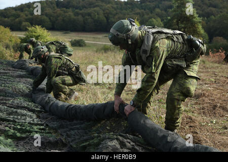 Litauischen Soldaten der Mechanisierte Infanterie-Brigade eiserne Wolf aufrollen Tarnnetze während der Vorbereitung zu einem Tactical Operations Center während der Übung Allied Geist V bei 7. Armee Training Command Hohenfels Trainingsbereich, Deutschland, 5. Oktober 2016 zu verlagern. Übung Allied Geist umfasst etwa 2.520 Teilnehmer aus acht NATO-Staaten und taktische Interoperabilität Übungen und Tests sichere Kommunikation innerhalb der Allianz-Mitglieder und Partner Nationen. (Foto: U.S. Army Spc. Nathaniel Nichols) Alliierten Geist V 161005-A-KF153-002 Stockfoto