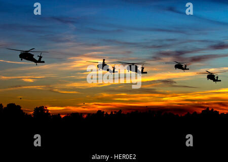 UH-60 Black Hawk-Hubschrauber von 2-10 Assault Helicopter Battalion, 10. Combat Aviation Brigade, kommen an der Einsteigezone, wie die Sonne über Fort-Trommel, NY, am 15. Oktober. Der Luftangriff, die Soldaten aus 1-89 Kavallerie beteiligt, markierte den Beginn einer massiven, ganze Nacht Operation im Rahmen der 10th Mountain Division jährliche Berggipfel Übung. (US Armee-Foto von Spc. Thomas Scaggs) Foto von Licht und Farbe im Photoshop ein ausgeglichenes 161015-A-TZ475-079 10. CAB führt massiven Luftangriff Ausbildung als Teil des Berges üben 161015-A-TZ475-079 Stockfoto