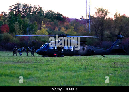 Soldaten aus 1-89 Kavallerie Eile, um auf einem UH-60 Black Hawk-Hubschrauber von 2-10 Assault Helicopter Battalion, 10. Combat Aviation Brigade, während ein Air assault Ausbildung an Fort-Trommel, NY, am 15. Oktober. Das Training war Teil der Berggipfel, einer jährlichen Veranstaltung 10th Mountain Division (Light Infantry), die mehr als eine Woche dauert. (Foto: U.S. Army Spc. Thomas Scaggs) Foto beschnitten, Licht und Farbe in Photoshop ausgewogen 161015-A-TZ475-101 10. CAB führt massiven Luftangriff Ausbildung als Teil des Berges üben 161015-A-TZ475-101 Stockfoto