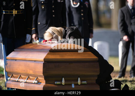 Ein Trauernder nähert sich den Sarg mit den Resten der US Army Staff Sgt. James F. Moriarty während seinem Graveside Service in Abschnitt 60 des Arlington National Cemetery, 5. Dezember 2016, in Arlington, VA. Moriarty war einer der drei Special Forces Soldaten aus der 5th Special Forces Group (Airborne), die am 4. November in Jordanien getötet wurden. (US Army Foto von Rachel Larue/Arlington National Cemetery/freigegeben) Graveside Service für US Army Staff Sgt. James F. Moriarty in Arlington National Cemetery 161205-A-DR853-168 Stockfoto