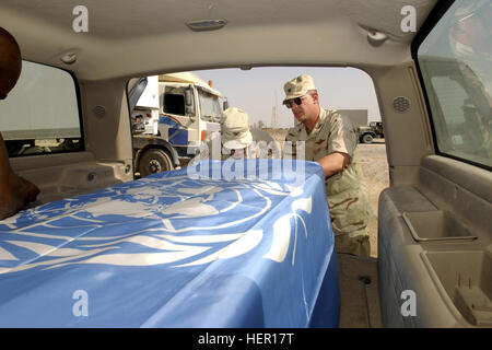 US-Armee (USA) Oberst (COL) Richard Dillon, Head of USA Leichenhalle Affairs und uns Air Force (USAF) COL Dennis Ployer, Commander, 447th Air Expeditionary Group (AEG), sichern Sie eine Flagge der Vereinten Nationen (UN) über das Verteilergetriebe des UNO-Chef-Botschafter in den Irak, Sergio Vieira de Mello, vor einer Trauerfeier am internationalen Flughafen von Bagdad. Sergio Vieira de Mello war ein Opfer eines Mordes LKW Bombenanschlag auf das Büro der humanitäre Koordinator der Vereinten Nationen in Bagdad, Irak, während der Operation IRAQI FREEDOM. Sergio Vieira de Mello DF-SD-04-02189 Stockfoto