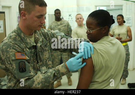 SPC. Joshua Ryan, Medic, 16. spezielle Truppen Bataillon, 16. Sustainment Brigade, verwaltet die Influenza-Impfstoff Staff Sgt Jacqueline Atkins, 574th-Quartiermeister Co., 16. STB an die Truppe medical Clinic im Kontingenz Operating Base Q-West, November 10. "Ich liebe es, ein Sanitäter in der Army", sagte Ryan, ein 20-Year-Old von Eleva, Wis "bekomme ich Menschen helfen, Reisen auf der ganzen Welt und lernen neue Dinge über meinen Job jeden Tag." Flickr - der US-Armee - www.Army.mil (233) Stockfoto