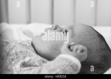 Babymädchen im Kinderbett liegen Stockfoto