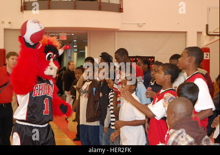 Die Chicago Bulls-Maskottchen, Benny, wirft die Basketball zu einer Masse von Fans, die abwechselnd wirft den Ball in den Korb auf der anderen Seite des Gymnasiums. Benny der Stier 1 Stockfoto