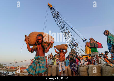 Chittagong: Männer entladen ein Schiff mit Reis in den Hafen von Karnaphuli Fluß, Division Chittagong, Bangladesch Stockfoto