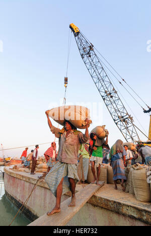 Chittagong: Männer entladen ein Schiff mit Reis in den Hafen von Karnaphuli Fluß, Division Chittagong, Bangladesch Stockfoto