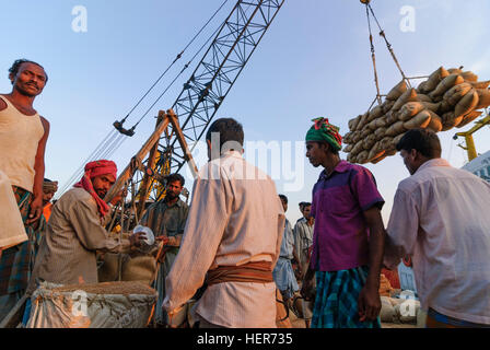 Chittagong: Männer entladen ein Schiff mit Reis in den Hafen von Karnaphuli Fluß, Division Chittagong, Bangladesch Stockfoto