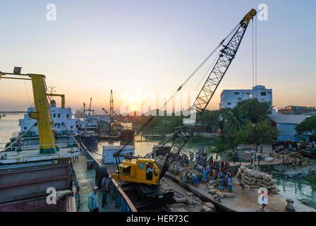 Chittagong: Männer entladen ein Schiff mit Reis in den Hafen von Karnaphuli Fluß, Division Chittagong, Bangladesch Stockfoto