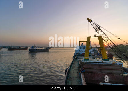 Chittagong: Männer entladen ein Schiff mit Reis in den Hafen von Karnaphuli Fluß, Division Chittagong, Bangladesch Stockfoto