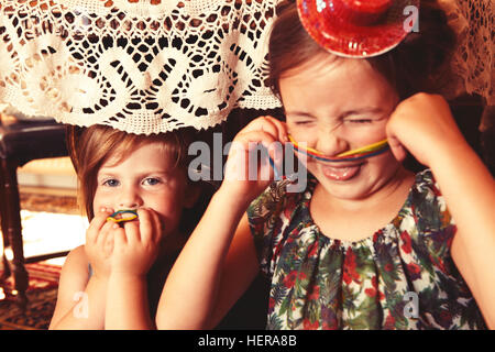 Partygirls Essen süß-saure Süßigkeiten Spaghetti unter dem Tisch Stockfoto