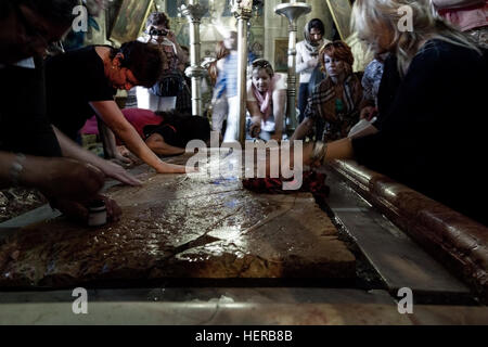 Jerusalem, Israel - 27. Oktober 2013: Pilger beten an den Stein der Salbung in der Kirche des Heiligen Grabes in Jerusalem. Stockfoto