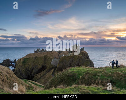 Zwei Fotografen erfassen Sie einen Winter-Sonnenaufgang über Dunnottar Castle, in der Nähe von Stonehaven im Nordosten Schottlands Stockfoto