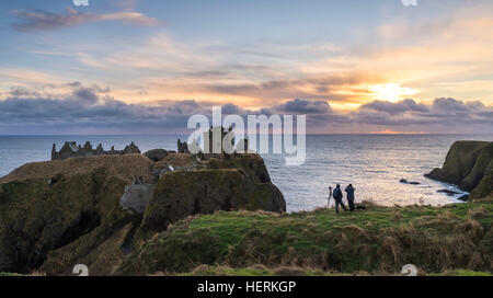 Zwei Fotografen erfassen Sie einen Winter-Sonnenaufgang über Dunnottar Castle, in der Nähe von Stonehaven im Nordosten Schottlands Stockfoto