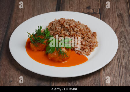 Buchweizengrütze und Frikadellen auf Holztisch Stockfoto