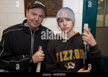 Vater unterstützende Sohn mit 13 Jahren nach einem langen Schule-Eishockey-Spiel. St Paul Minnesota MN USA Stockfoto