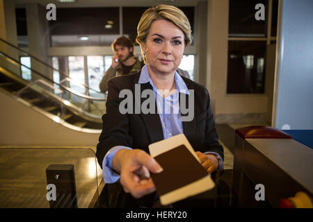 Geschäftsfrau, die Übergabe seiner Bordkarte am Schalter im Flughafen-terminal Stockfoto