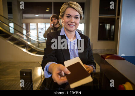 Geschäftsfrau, die Übergabe seiner Bordkarte am Schalter im Flughafen-terminal Stockfoto