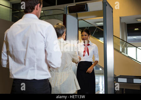 Rückansicht des Frau Übergabe ihrer Bordkarte an den Mitarbeiterinnen Stockfoto