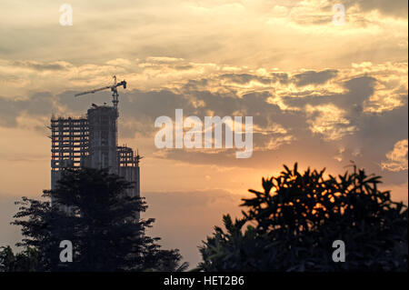 Silhouette der Wolkenkratzer im Bau mit modernen Bauweisen, gegen die Einstellung von Sonne und Wolken Stockfoto
